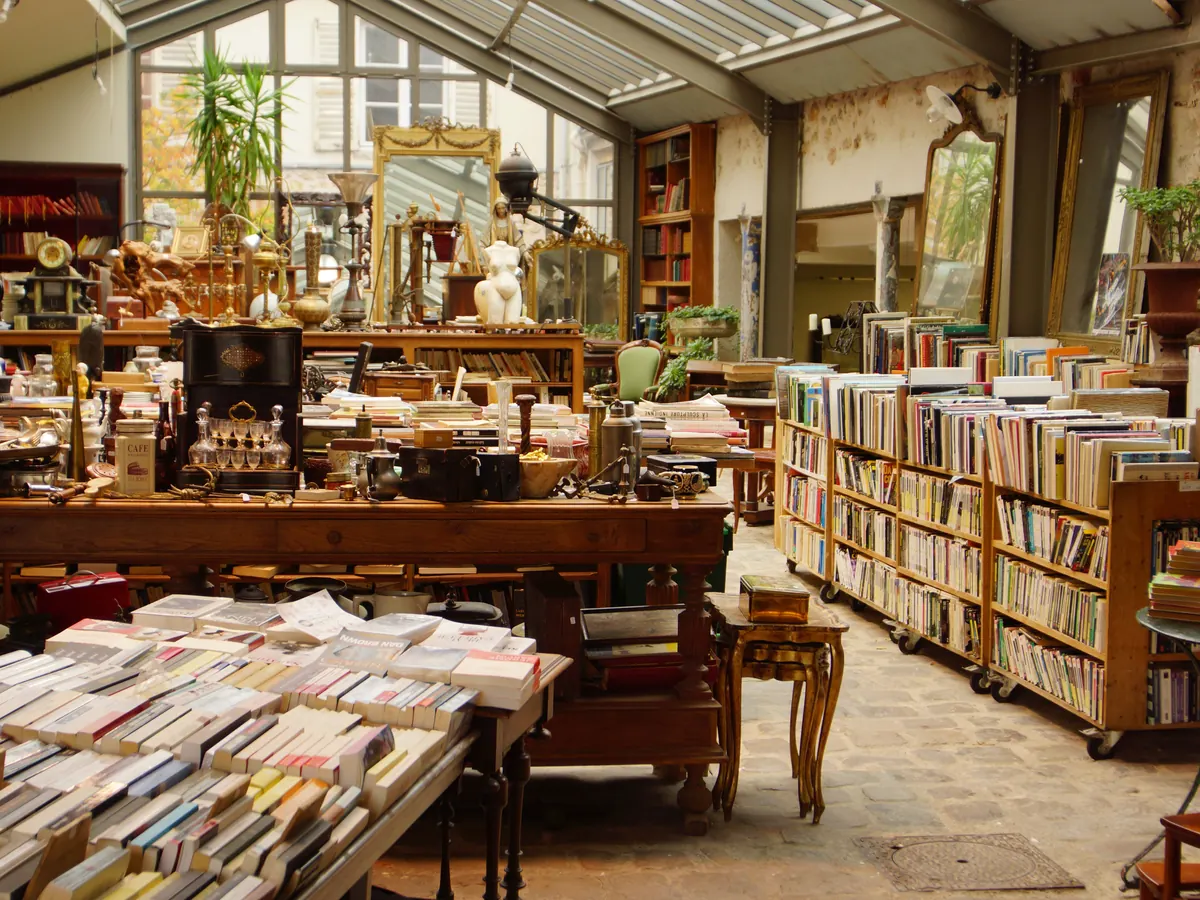 Innenraum eines Antiquariats mit vollen Bücherregalen und Tischen
