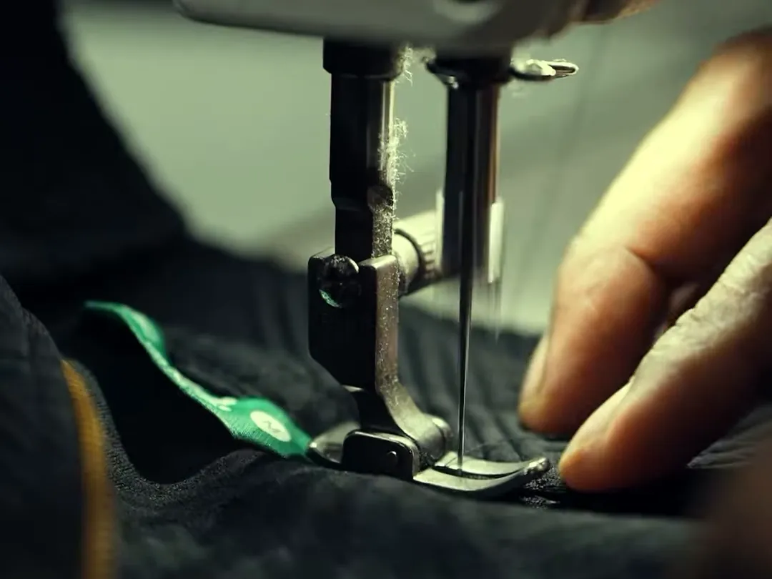 Nähmaschine näht ein Kleidungsstück mit eingenähtem Label